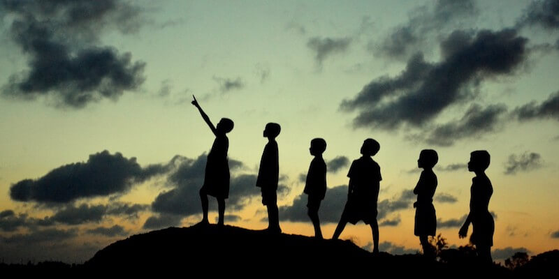 Foto di bambini che guardano in cielo al tramonto