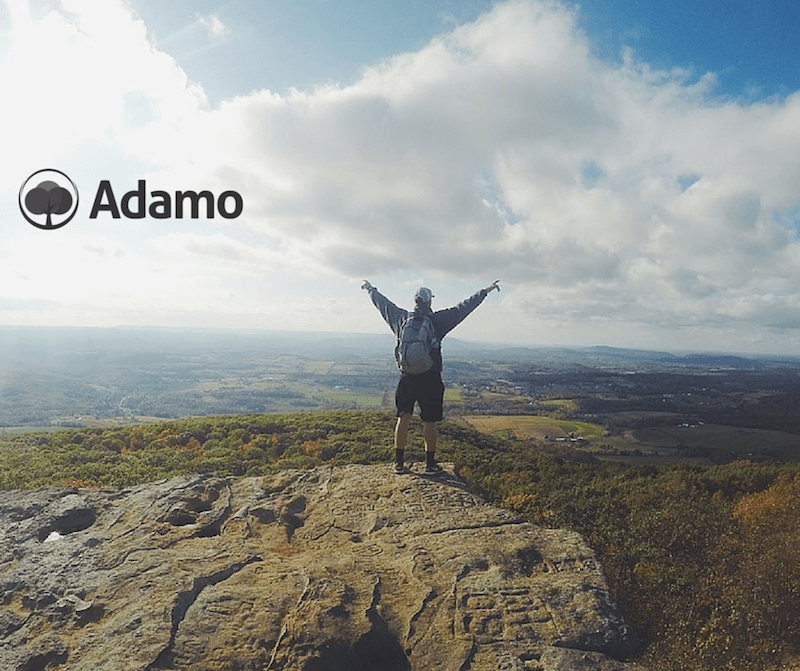 Logo di Adamo su foto panorama di montagna